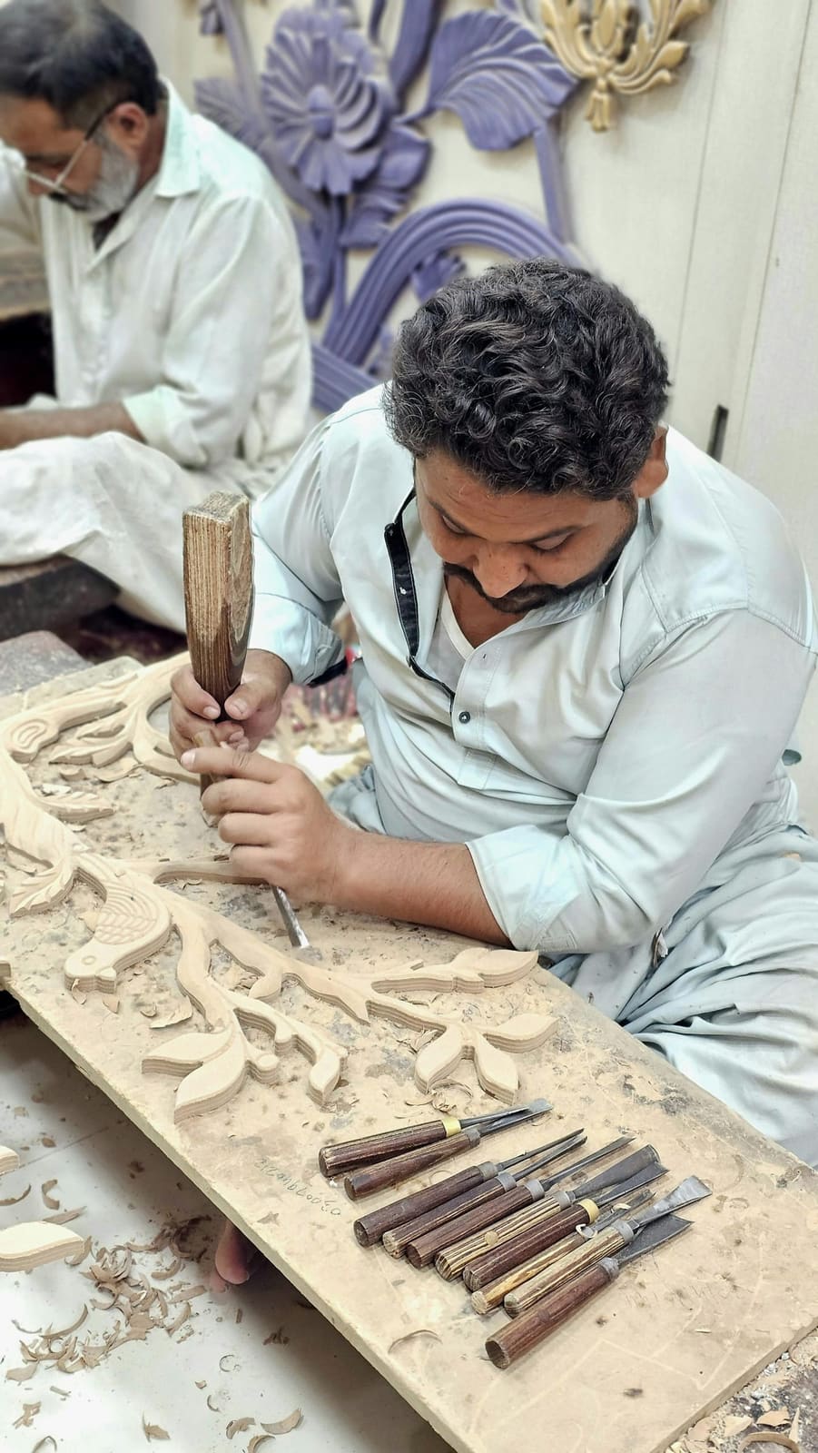 Carpenter shaping a wooden furniture piece at Virsa Wood